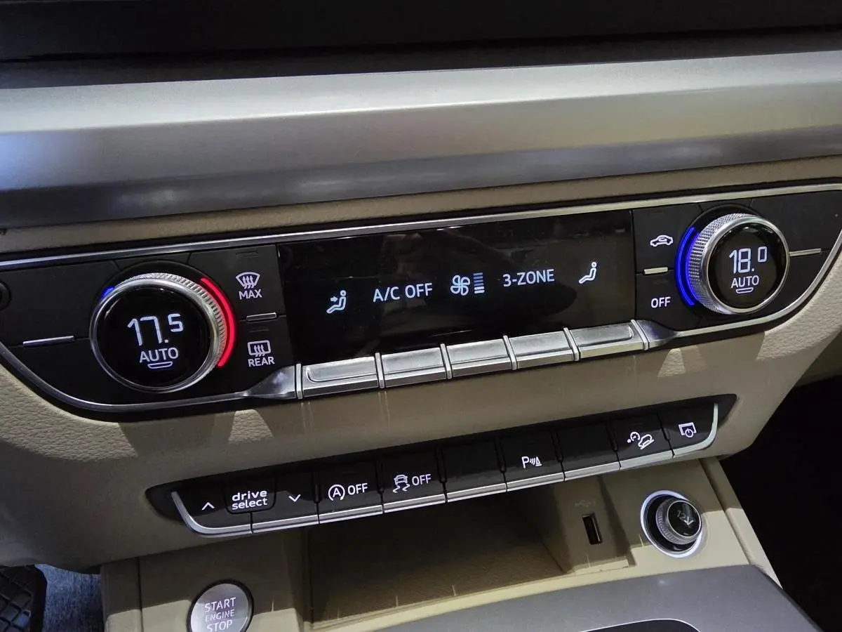 Tableau de bord beige de l'Audi Q5 2019 avec commandes climatisation 3 zones et boutons multifonctions.