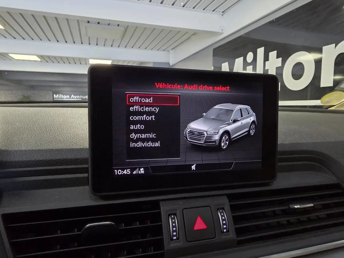 Écran central affichant le menu Audi drive select avec illustration d'un Q5 gris en vue 3/4 avant.
