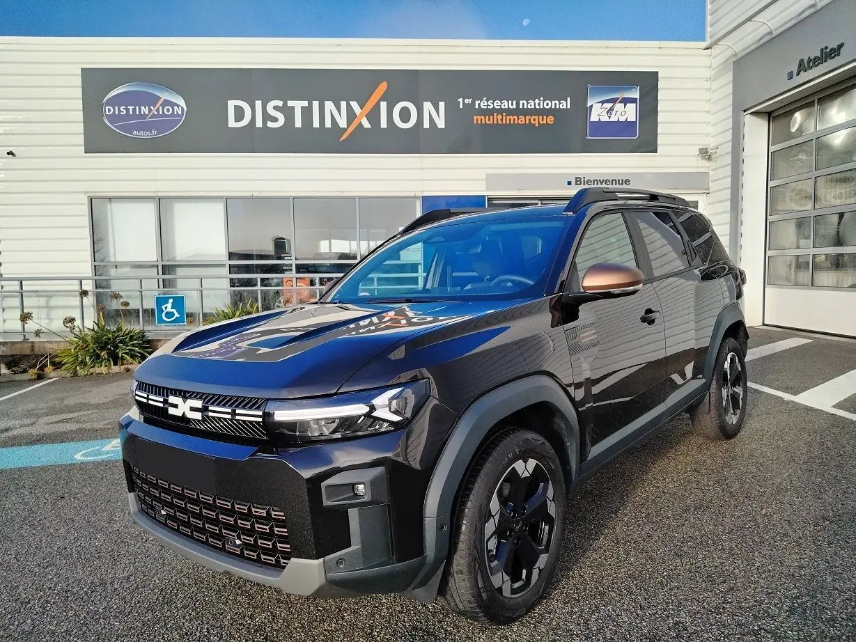 Vue 3/4 avant droite d'un Dacia Bigster noir 2025 avec jantes noires et coques de rétroviseurs bronze métallisé.