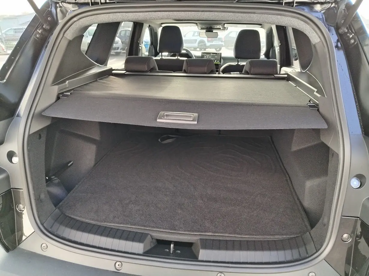 Coffre ouvert du Dacia Bigster noir 2025, vue arrière montrant la plage arrière et l'espace de chargement vide.