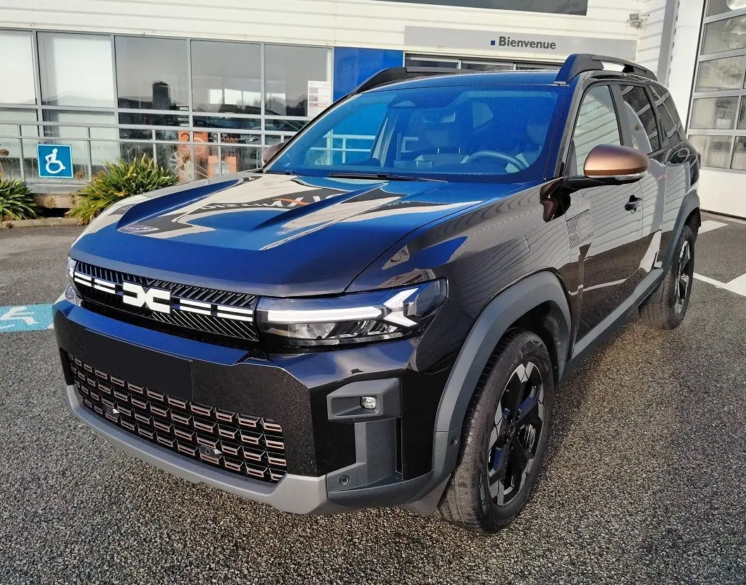 Vue 3/4 avant droite du Dacia Bigster noir 2025 avec calandre distinctive et jantes biton noires.