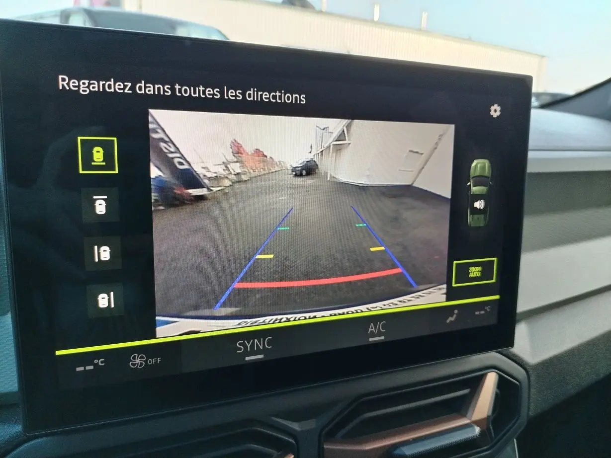 Écran multimédia affichant la caméra de recul du Dacia Bigster 2025, vue arrière avec lignes de guidage colorées.