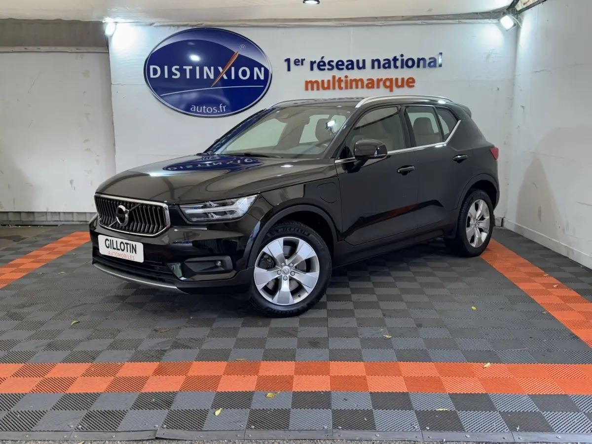 Volvo XC40 Recharge T5 noir en 3/4 avant droit, stationné en intérieur sur sol à damiers gris et orange.
