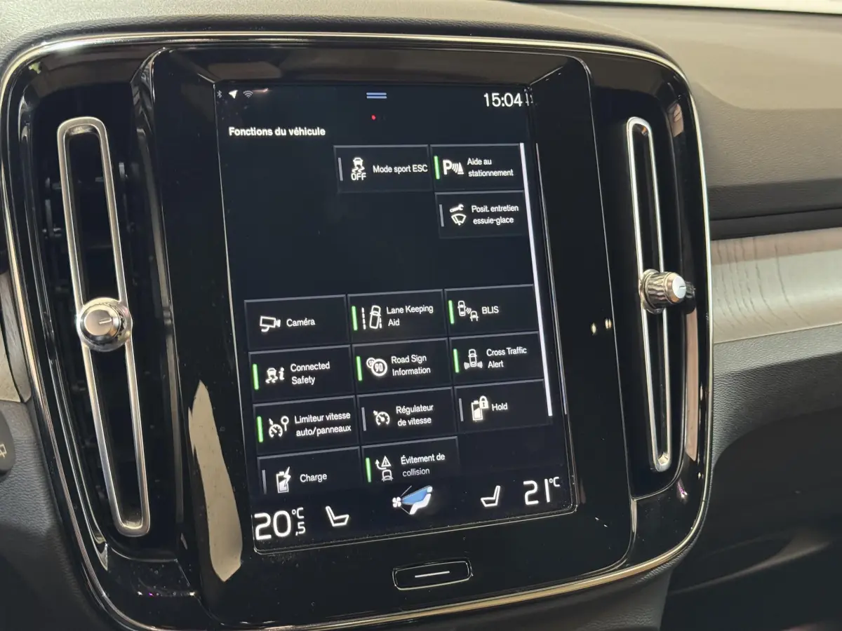 Écran tactile central affichant les fonctions du véhicule dans l'habitacle du Volvo XC40 noir, vue de face rapprochée.
