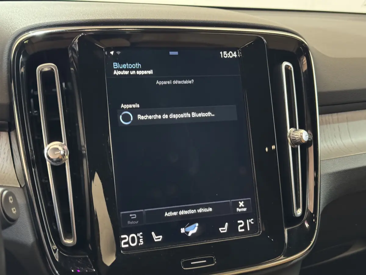 Écran tactile central noir du Volvo XC40 Recharge T5 Inscription 2021, avec commandes climatisation affichées.