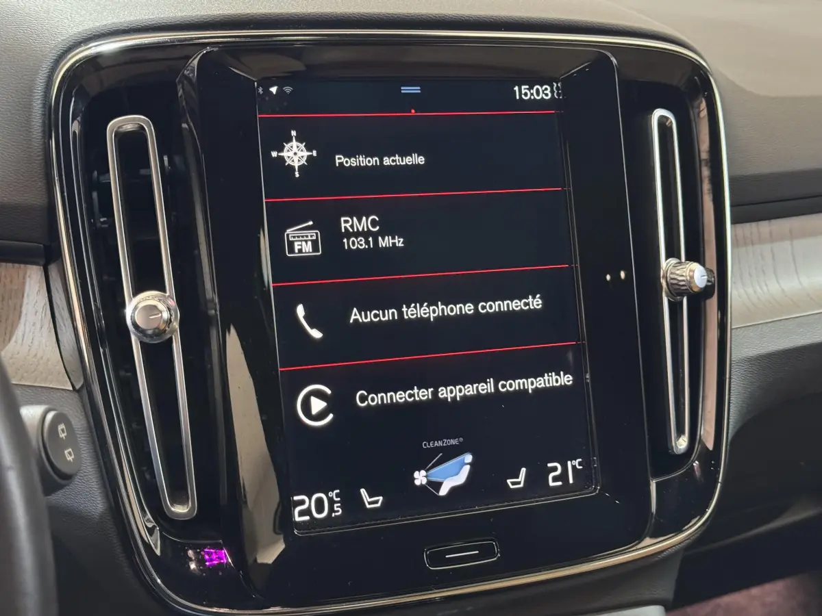 Écran tactile central du tableau de bord du Volvo XC40 noir, affichant la radio et la climatisation en intérieur.