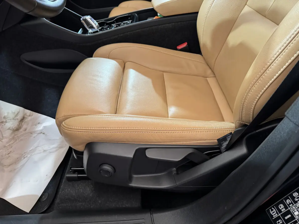 Gros plan sur le siège avant droit en cuir beige du Volvo XC40 Recharge T5 2021, avec commandes de réglage visibles.