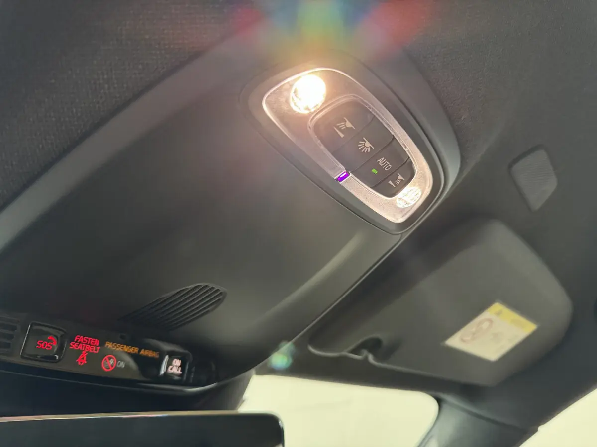 Plafonnier allumé avec commandes d’éclairage et alertes de sécurité dans l’habitacle noir du Volvo XC40 Recharge T5.