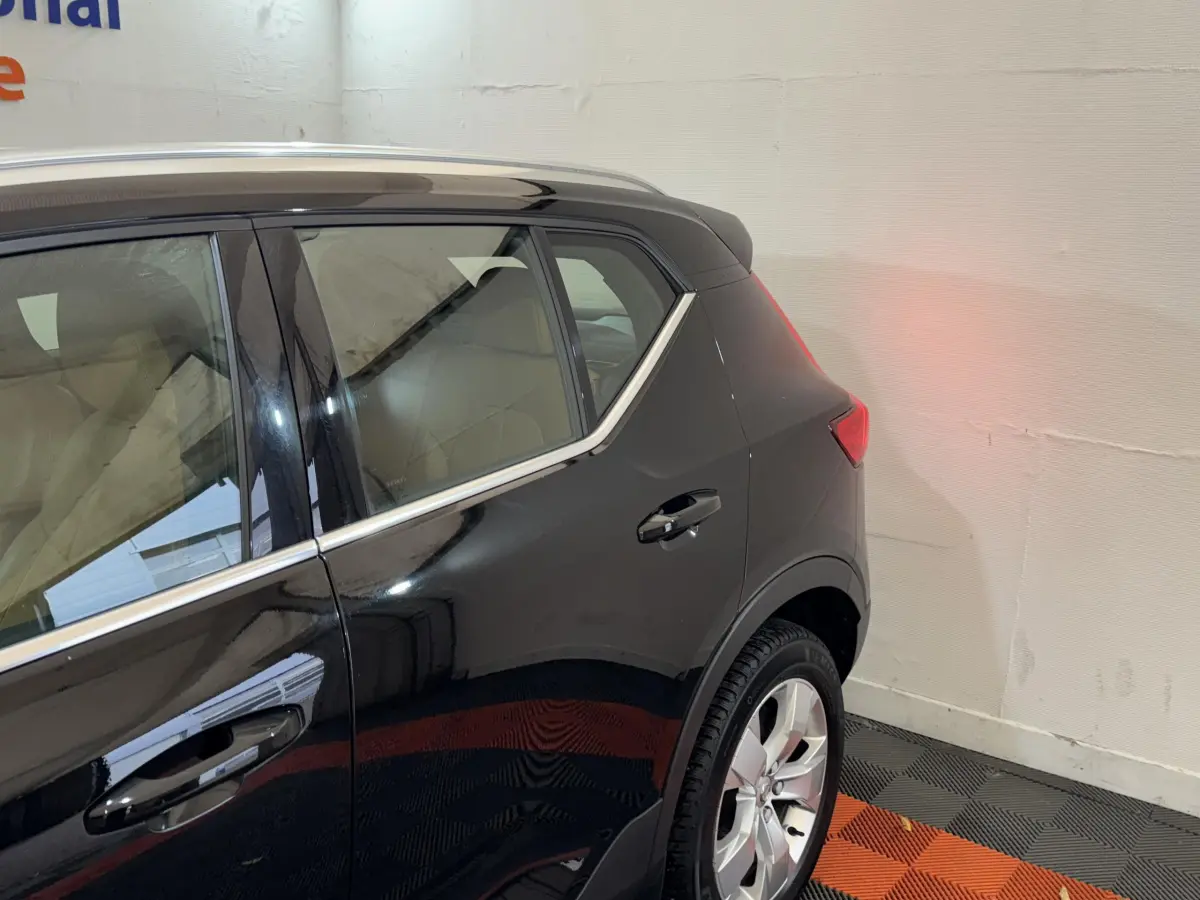 Vue latérale arrière droite d’un Volvo XC40 Recharge T5 noir, soulignant la ligne de toit et les jantes alliage.