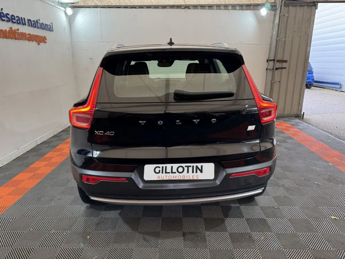 Vue arrière d'un Volvo XC40 noir avec feux arrière en forme de L et logo centré sur le hayon.