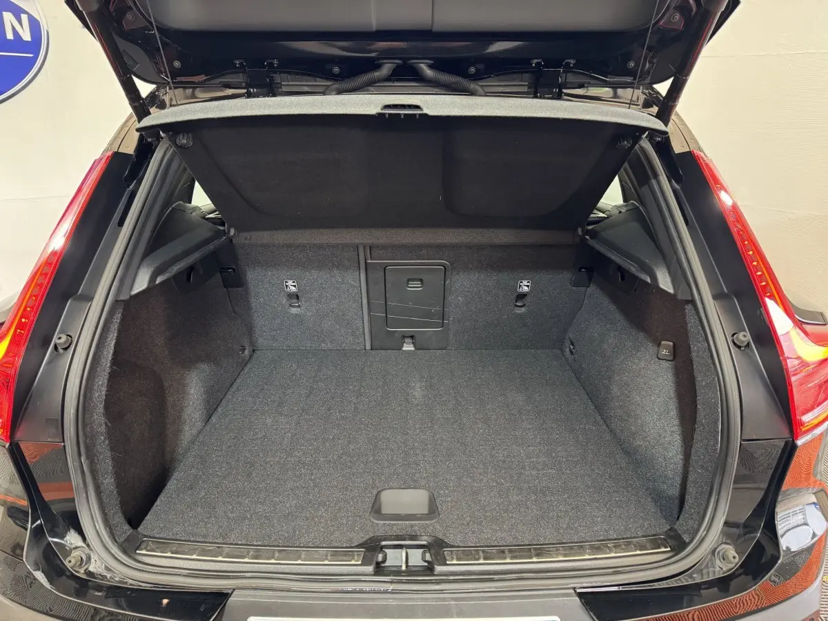 Coffre ouvert noir du Volvo XC40 Recharge T5 262 DCT7 Inscription, vue arrière montrant l'espace de chargement vide.