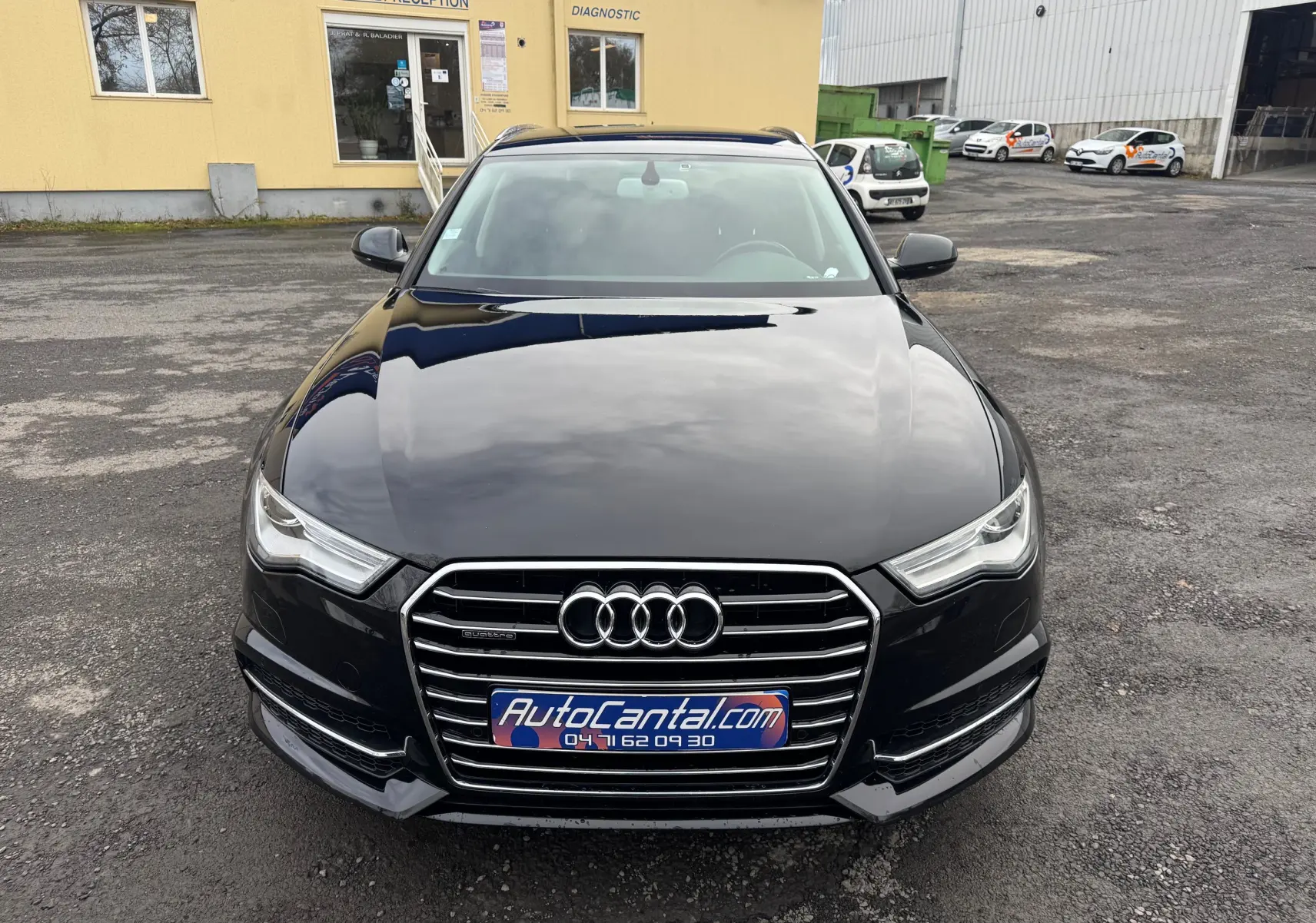 Vue avant d'une Audi A6 Avant noire de 2015, mettant en valeur la calandre chromée et les phares LED distinctifs.