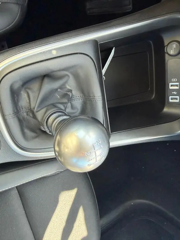 Gros plan sur le levier de vitesses manuel noir de la Jeep Avenger 2025, avec console centrale et ports USB visibles.