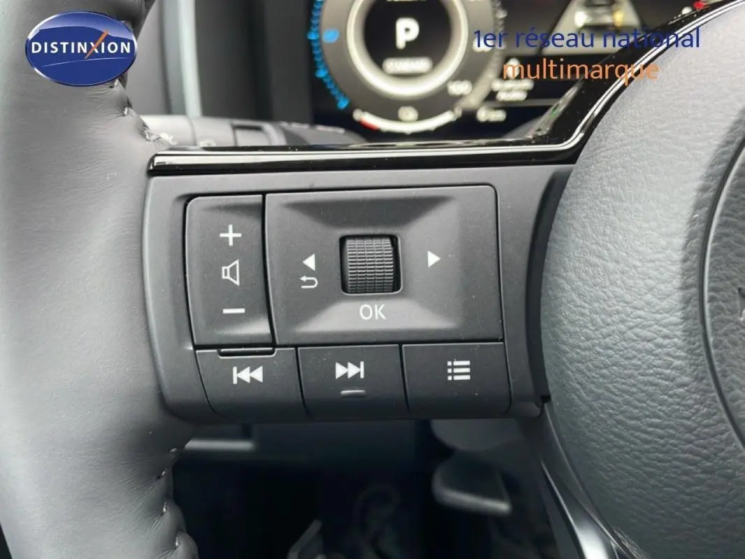 Gros plan sur les commandes multifonctions à gauche du volant du Nissan Qashqai noir 2025, affichage digital en arrière-plan.