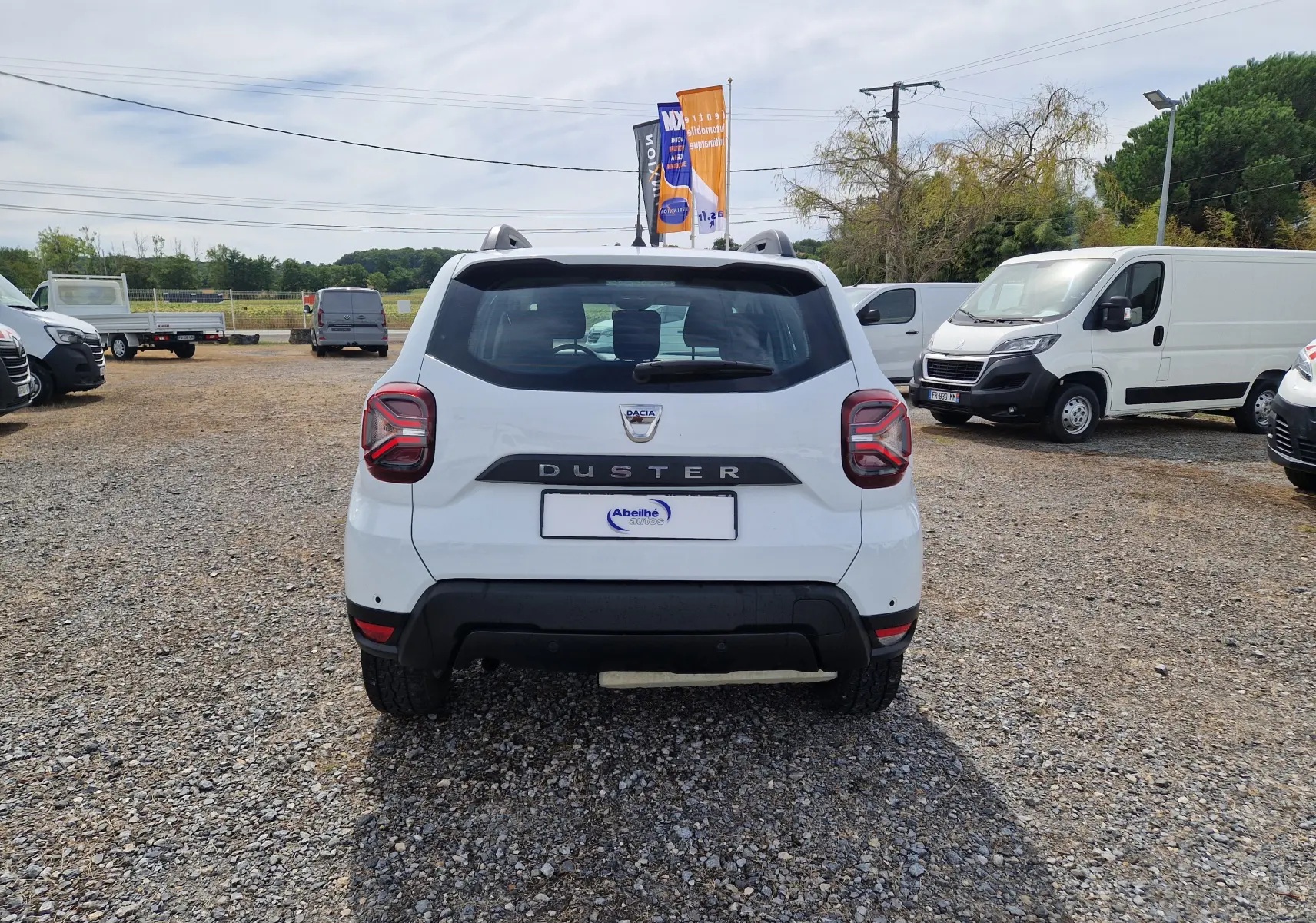 Vue arrière d'un Dacia Duster blanc 4x4 2022, avec logo et nom du modèle bien visibles sur le hayon.