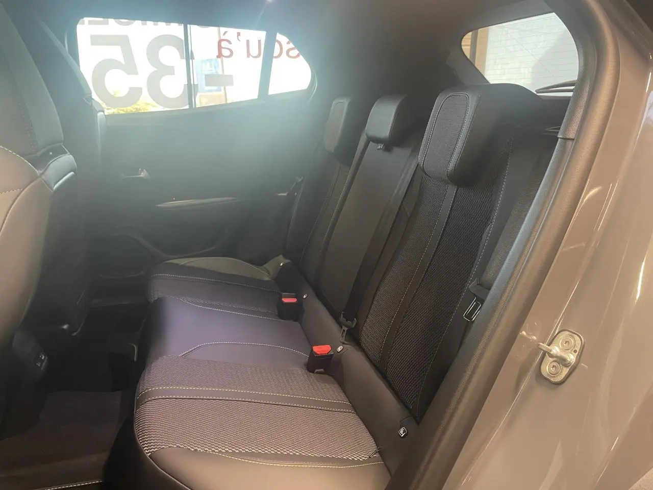 Vue intérieure côté droit sur la banquette arrière noire avec surpiqûres contrastantes du Peugeot 2008 gris.