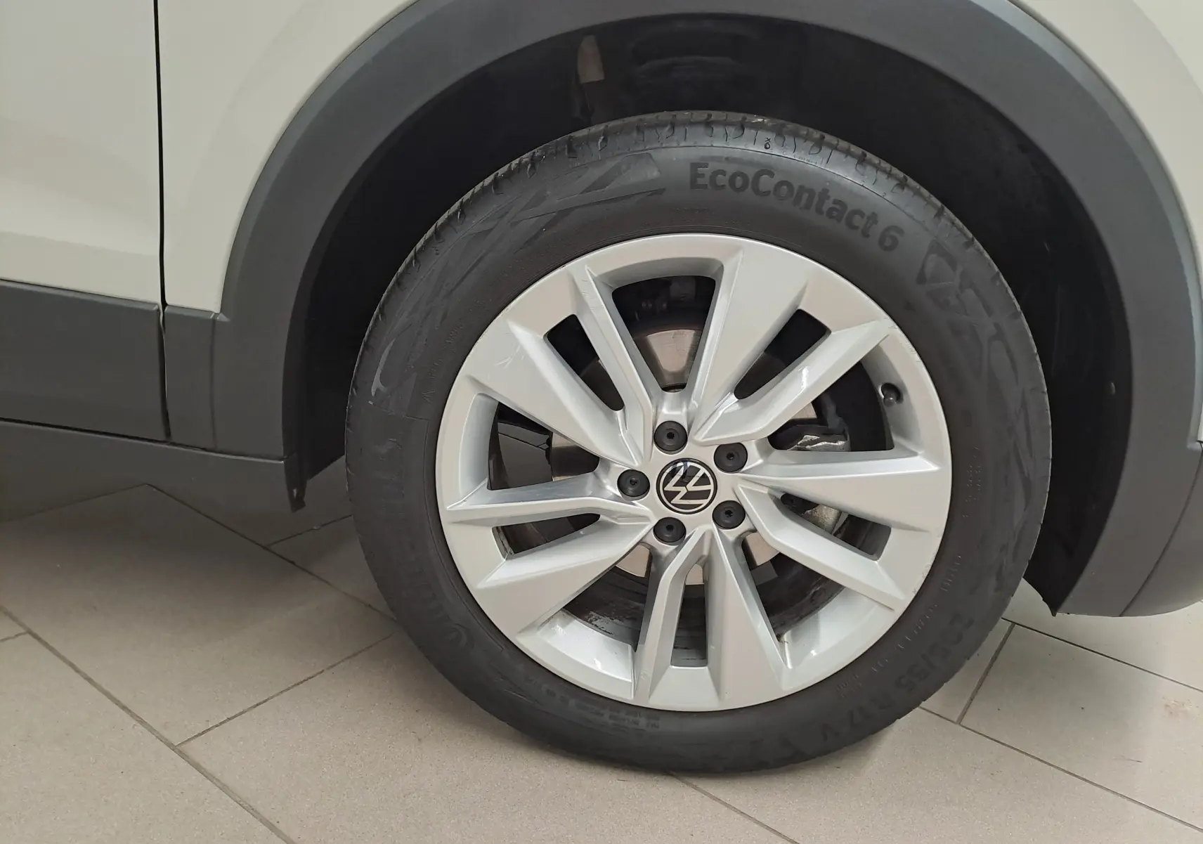 Gros plan sur la roue avant droite du Volkswagen T-Cross 2024 Gris Ascot avec jante alliage et pneu EcoContact 6.
