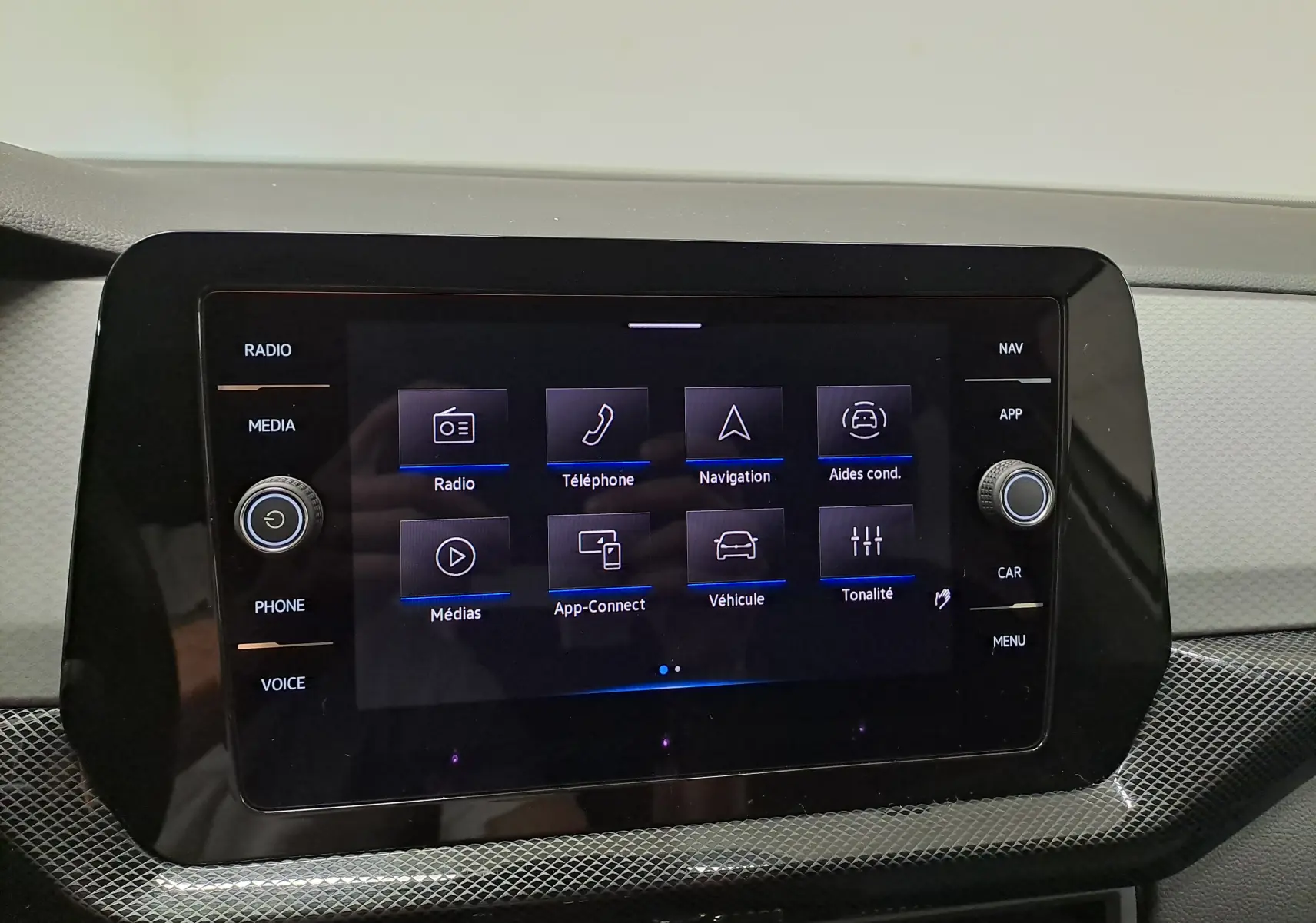 Écran tactile central du Volkswagen T-Cross 2024 affichant les options radio, téléphone, navigation et aides à la conduite.