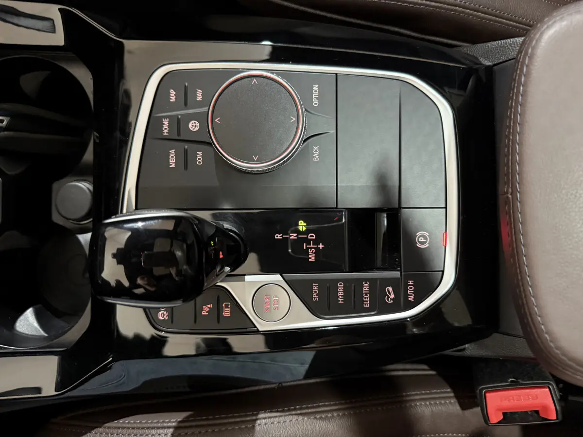 Gros plan sur la console centrale noire et boutons de commande du levier de vitesse du BMW X3 bleu hybride 2023.