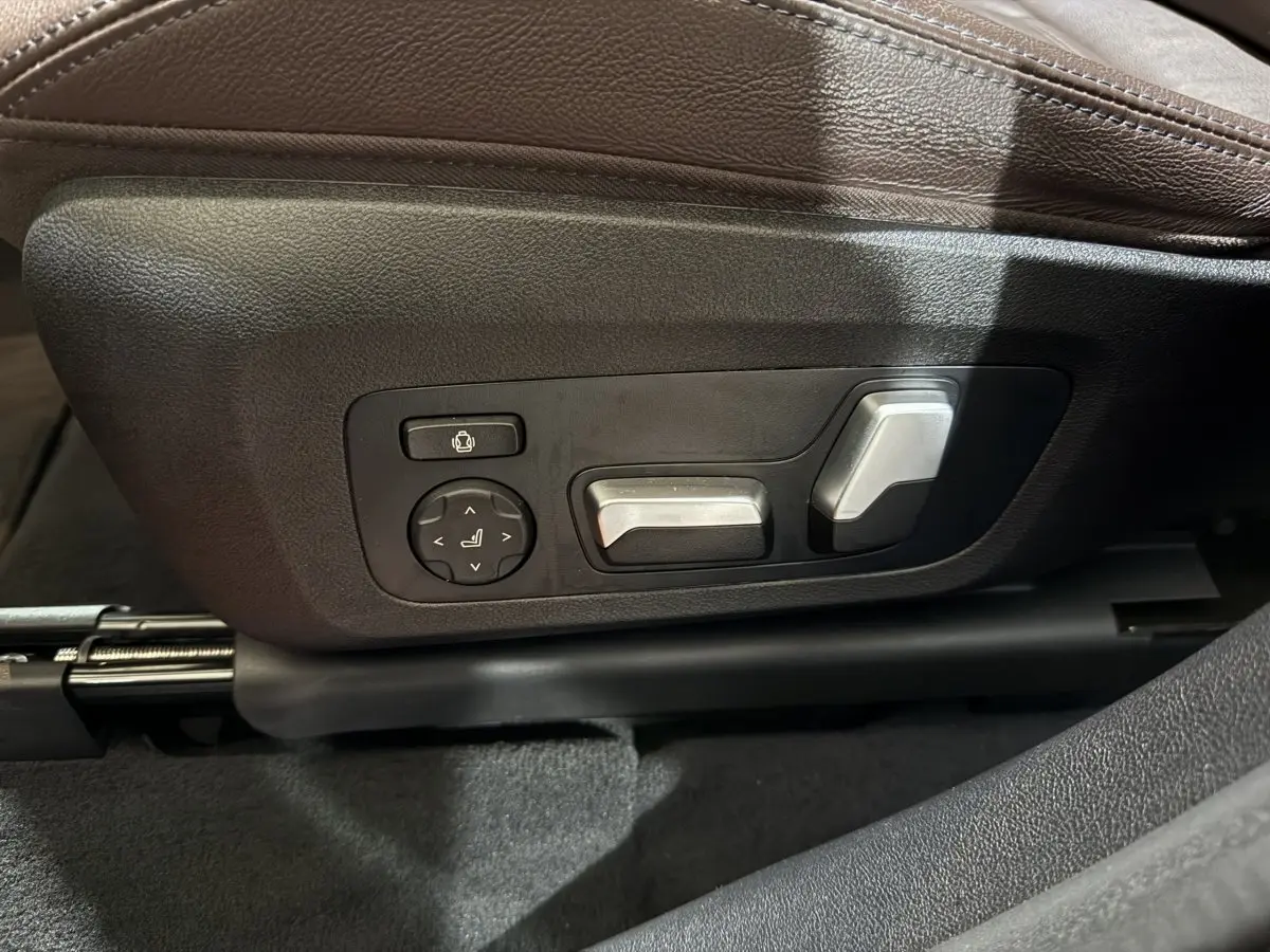 Gros plan sur les commandes de réglage électrique du siège côté conducteur d'un BMW X3 bleu 2023 M Sport.