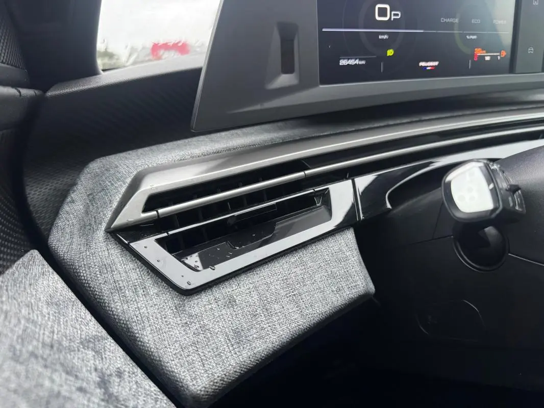 Détail de la sortie d’air côté gauche du tableau de bord gris clair du Peugeot 3008 Hybrid 145 e-DCS6 Allure noir 2025.