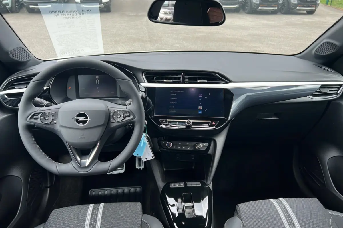 Vue intérieure frontale du tableau de bord et volant cuir noir de l’Opel Corsa Hybrid 110 e-DCT6 blanc Kontur 2026.