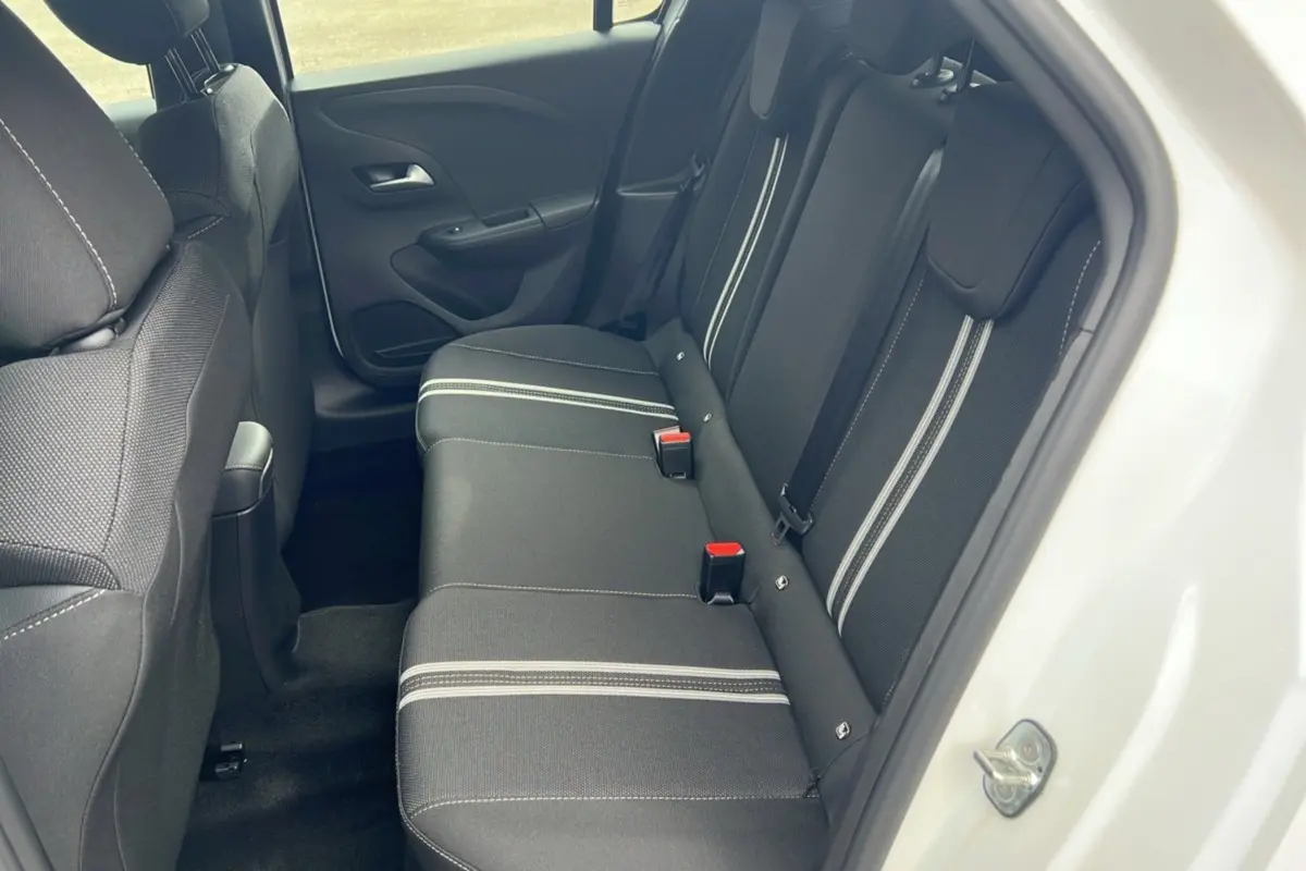 Vue intérieure côté droit sur la banquette arrière noire avec bandes blanches de l’Opel Corsa Hybrid blanc Kontur 2026.