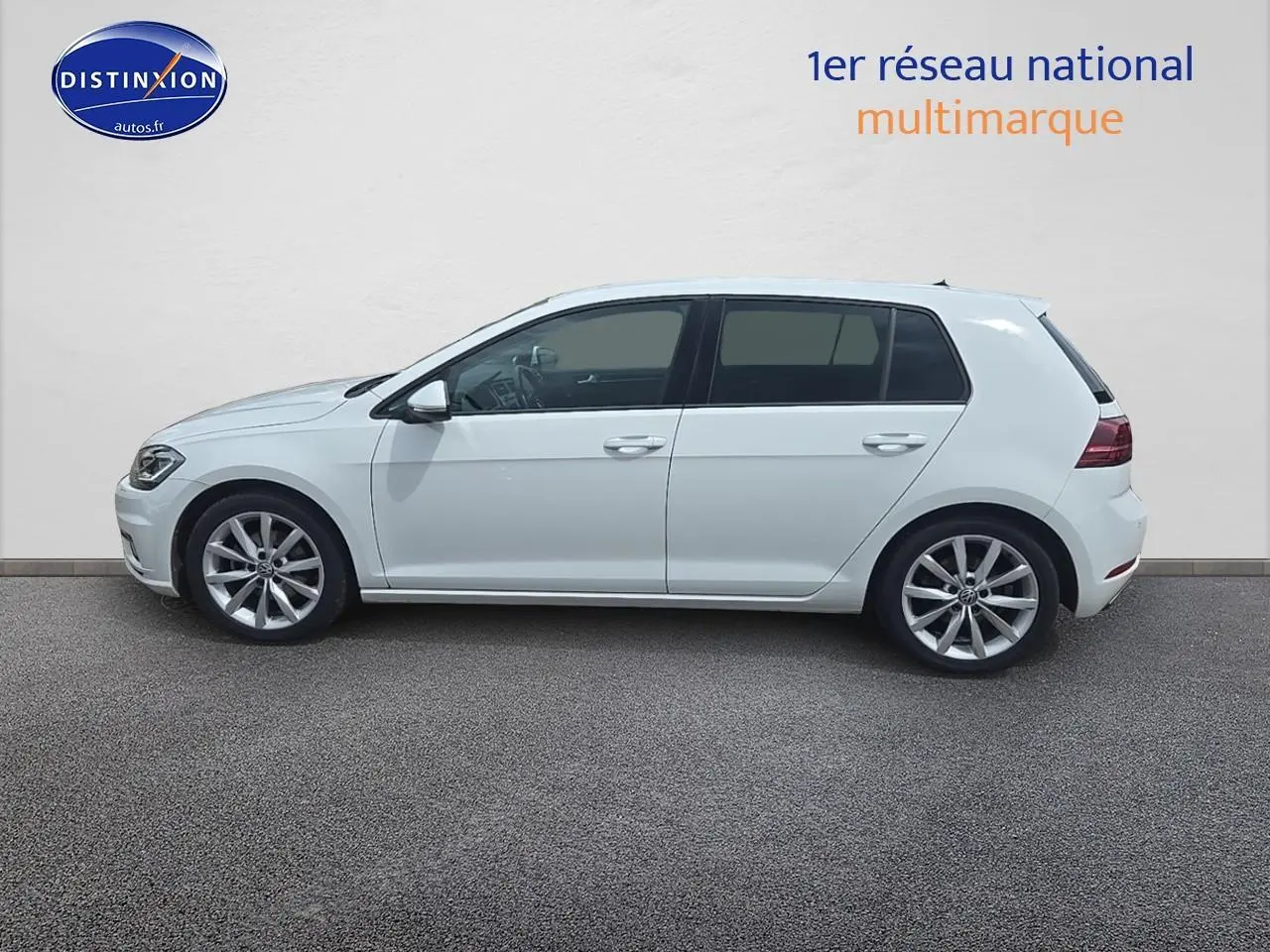Profil côté gauche d’une Volkswagen Golf blanche 2019 avec jantes alliage et vitres teintées.