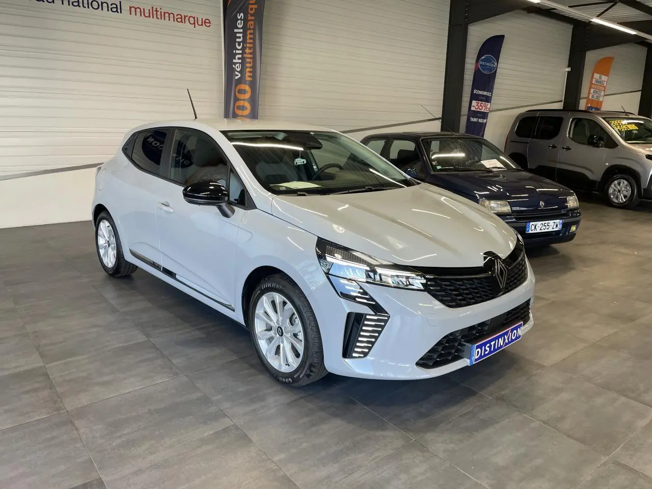 Renault Clio 2025 gris Rafale en 3/4 avant droit, avec calandre noire et feux LED distinctifs.