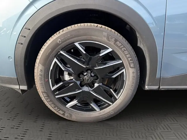 Gros plan sur la jante 19 pouces noire et argentée du côté gauche d’un Peugeot 3008 bleu 2026.
