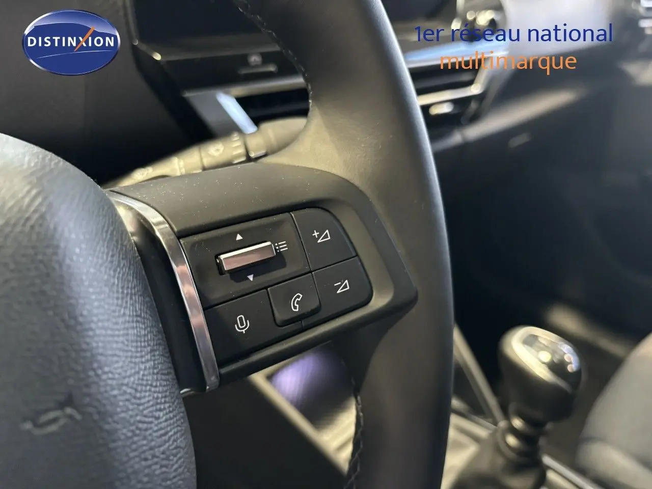 Gros plan sur la commande de volume au volant d'une Citroën C4 blanche essence 2022, boîte manuelle visible en arrière-plan.