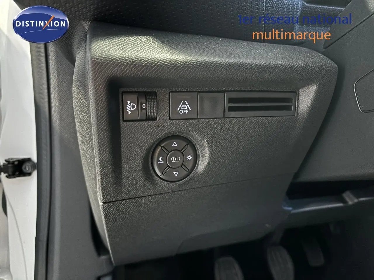 Gros plan sur les commandes de réglage des phares et aides à la conduite côté gauche d'une Citroën C4 blanche 2022.