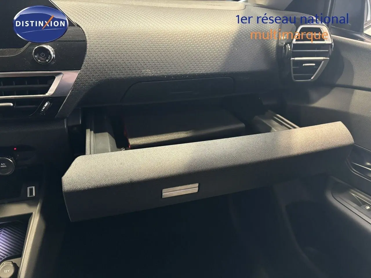 Intérieur de la Citroën C4 2022 blanc, vue sur la boîte à gants ouverte côté passager avec tableau de bord texturé.