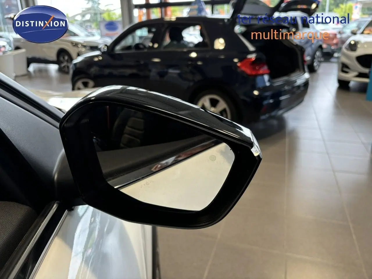 Rétroviseur extérieur noir du côté gauche d'une Citroën C4 blanche 2022 en showroom.