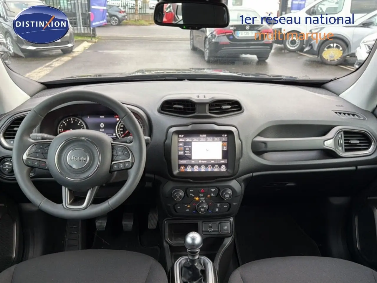 Vue intérieure avant du Jeep Renegade noir 2022, tableau de bord moderne avec écran tactile et volant multifonction.