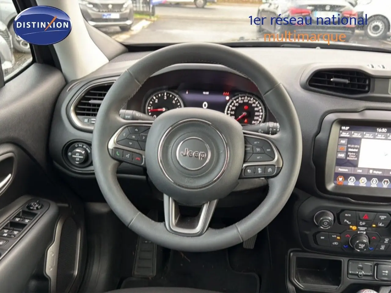 Vue intérieure centrée sur le volant Jeep d'un Renegade noir 2022, avec tableau de bord et écran tactile visibles.