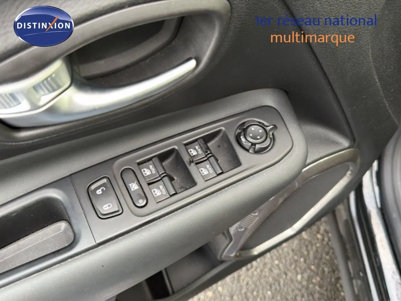 Gros plan sur les commandes de lève-vitres et rétroviseurs côté conducteur d'une Jeep Renegade noire 2022.