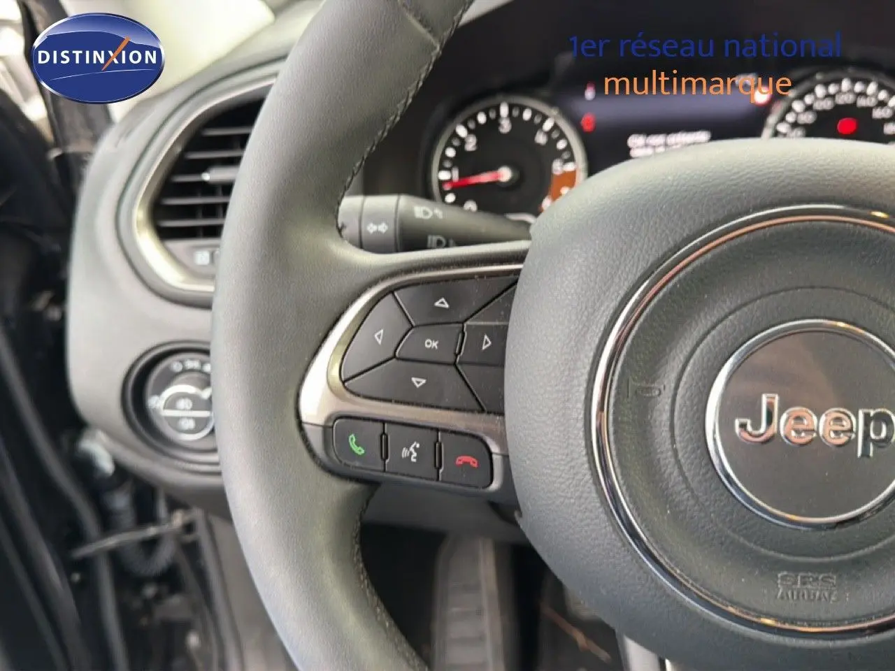 Vue rapprochée du volant noir de la Jeep Renegade 2022 avec commandes intégrées et tableau de bord partiel.