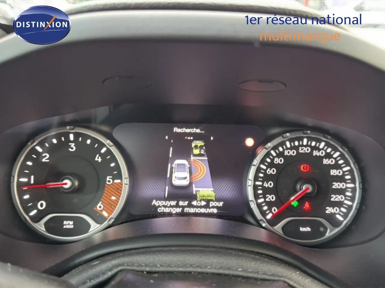 Tableau de bord de Jeep Renegade noir 2022 avec compte-tours, vitesse et écran central affichant une aide au stationnement.