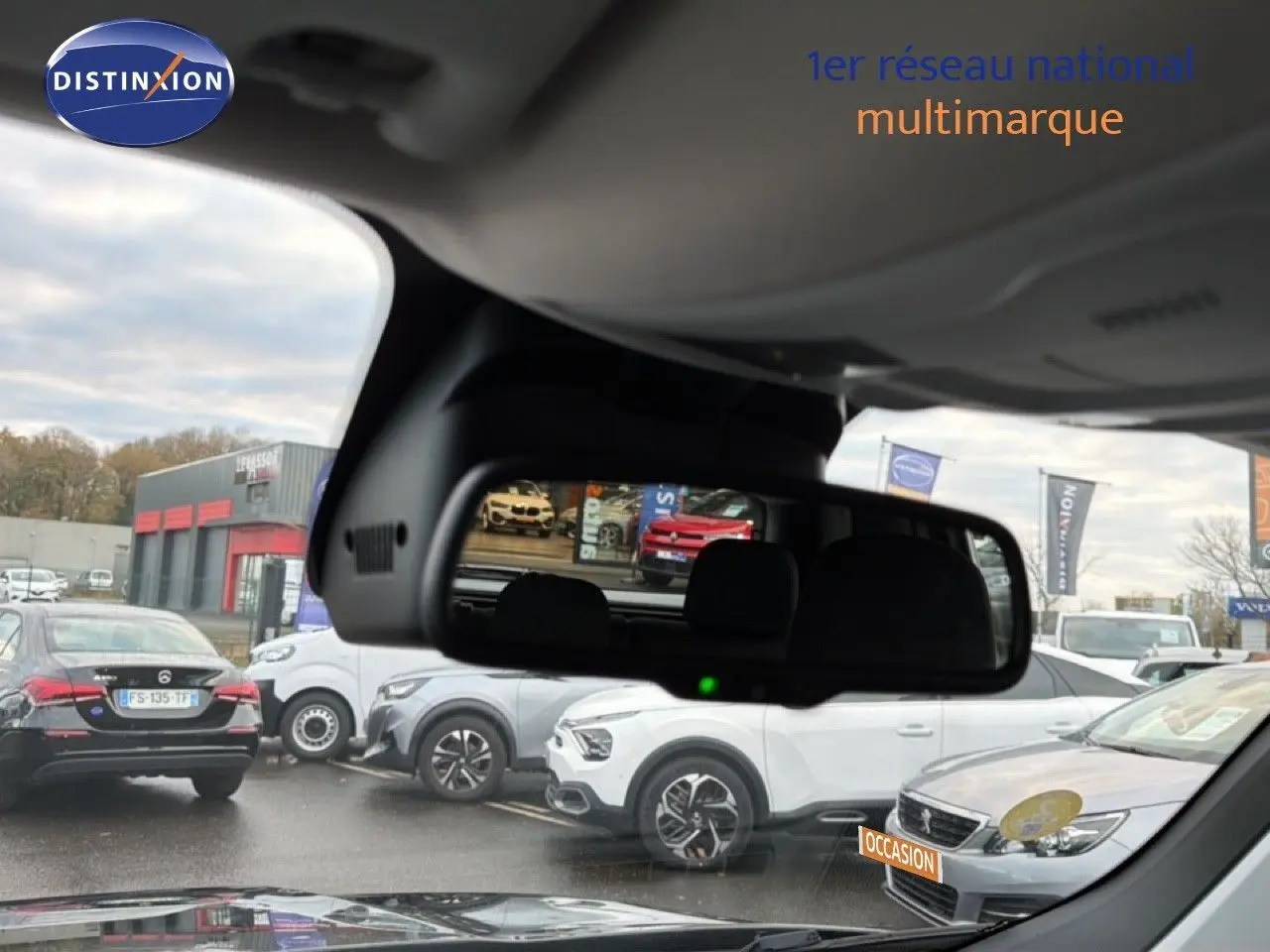 Vue depuis l'intérieur montrant le rétroviseur central avec reflet d'un Jeep Renegade noir en 3/4 arrière.