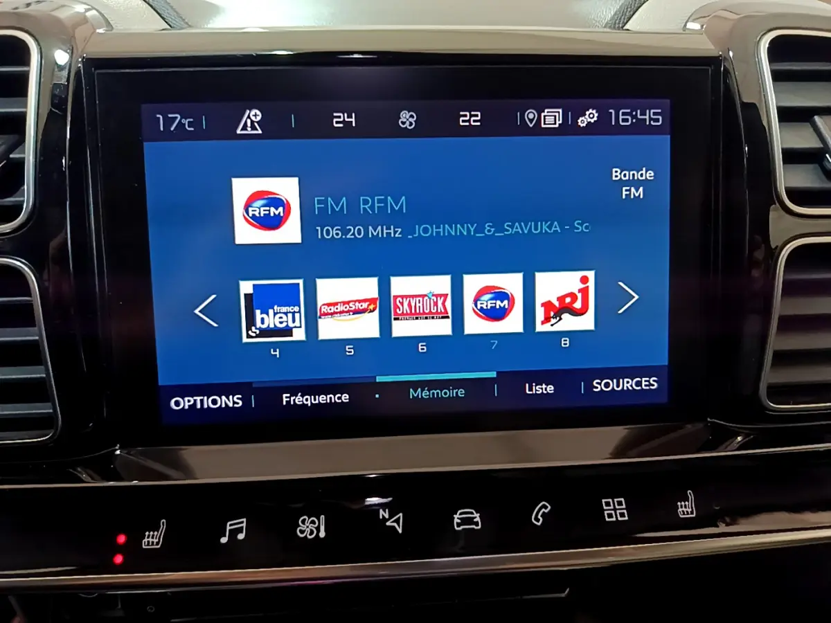 Écran tactile central du tableau de bord du Citroën C5 Aircross Hybrid noir, affichant les stations radio FM.