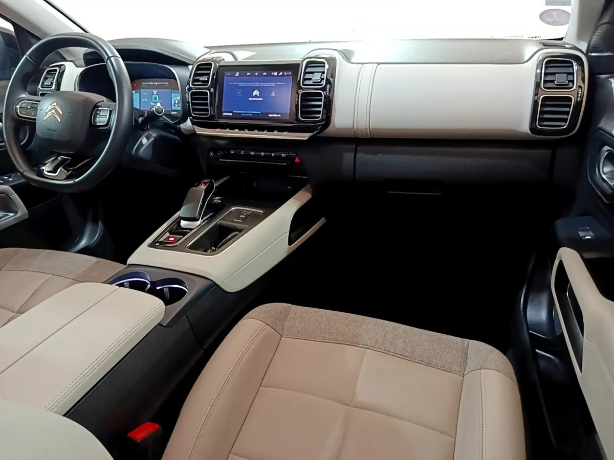 Intérieur clair du Citroën C5 Aircross Hybrid 225, vue côté passager avec tableau de bord et écran tactile central.