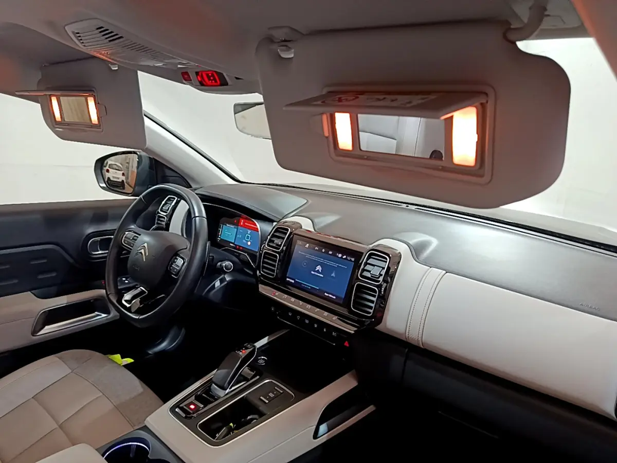 Intérieur du Citroën C5 Aircross Hybrid noir, vue côté conducteur sur tableau de bord et volant cuir multifonctions.