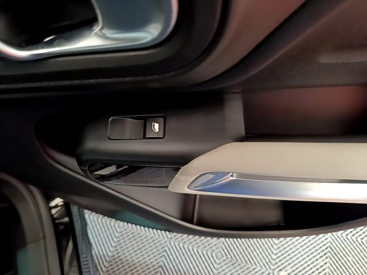 Détail de la commande de lève-vitre côté conducteur dans l'intérieur noir et beige du Citroën C5 Aircross Hybrid 225 ë-EAT8 Shine 2021.