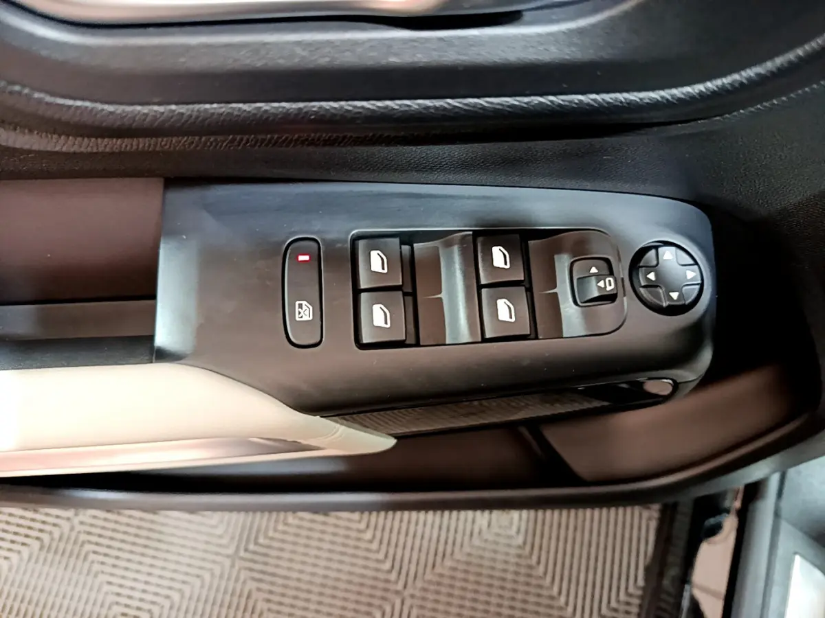 Gros plan sur les commandes des vitres et rétroviseurs côté gauche d'une Citroën C5 Aircross Hybrid noire.