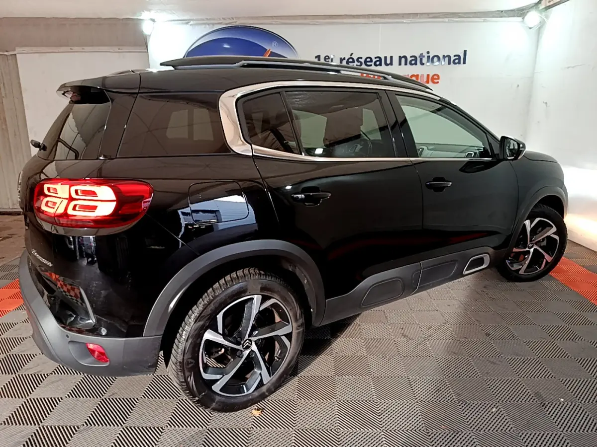 Vue 3/4 arrière droite d'un Citroën C5 Aircross Hybrid 225 noir avec feux arrière LED et jantes alliage bicolores.