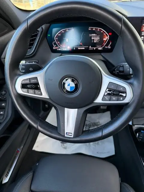 Vue rapprochée du volant cuir noir BMW Série 1 118d 2024 avec affichage numérique et commandes multifonctions.
