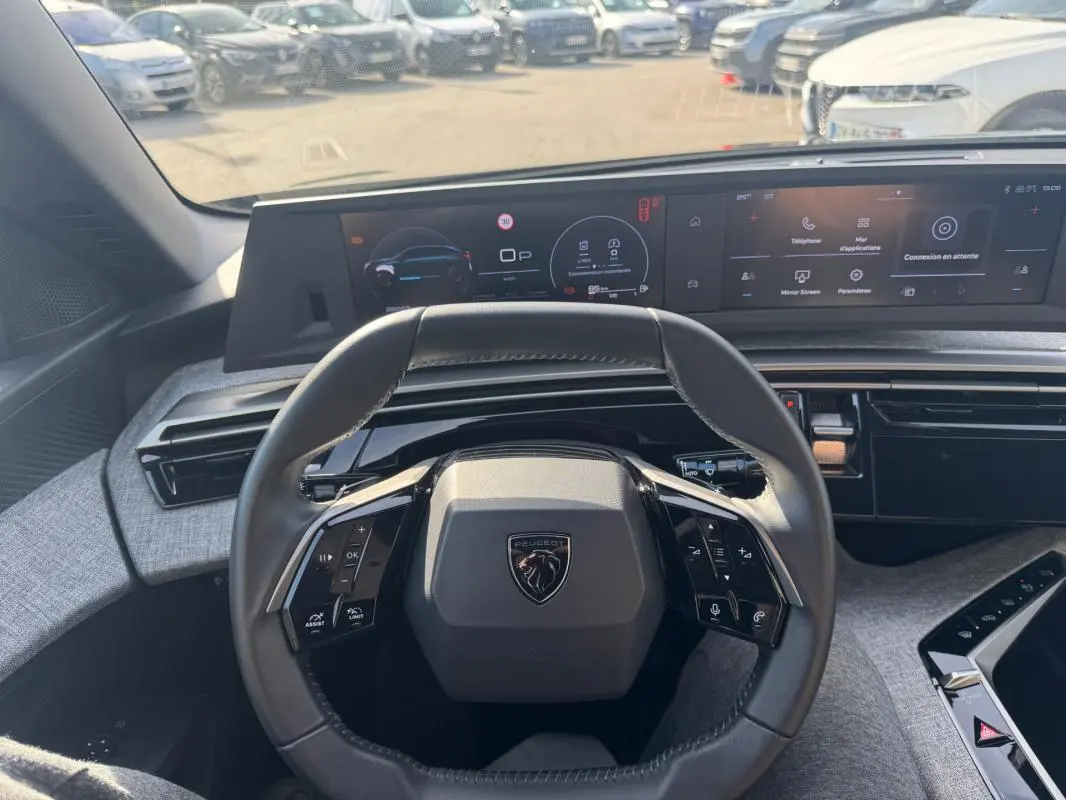 Vue intérieure centrée sur le volant compact et le cockpit numérique du Peugeot 3008 Hybrid 145 noir 2025.