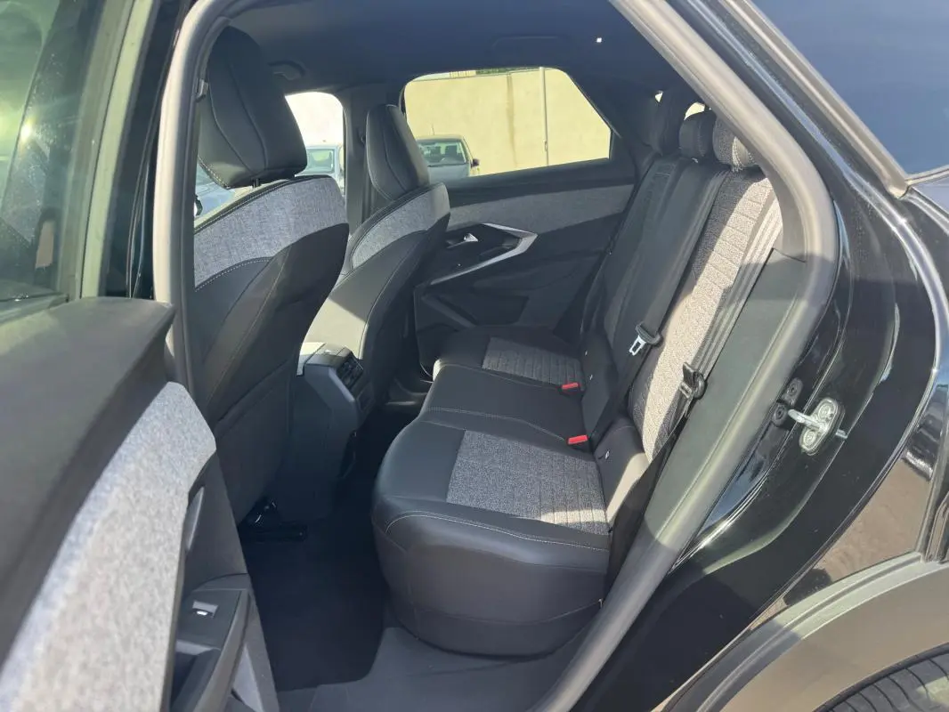 Vue intérieure arrière côté droit du Peugeot 3008 Hybrid 145 noir, sièges bi-matière tissu et cuir gris.
