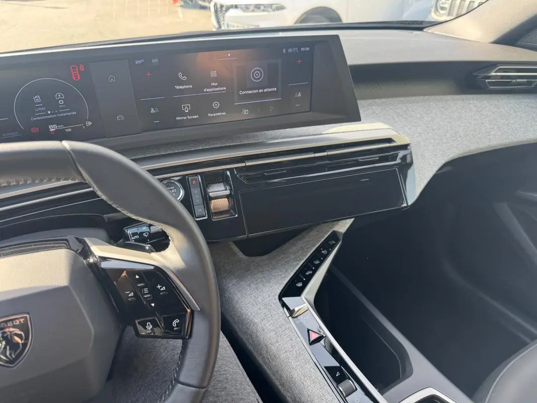 Vue intérieure côté conducteur du tableau de bord et console centrale du Peugeot 3008 Hybrid 145 Allure 2025 noir.